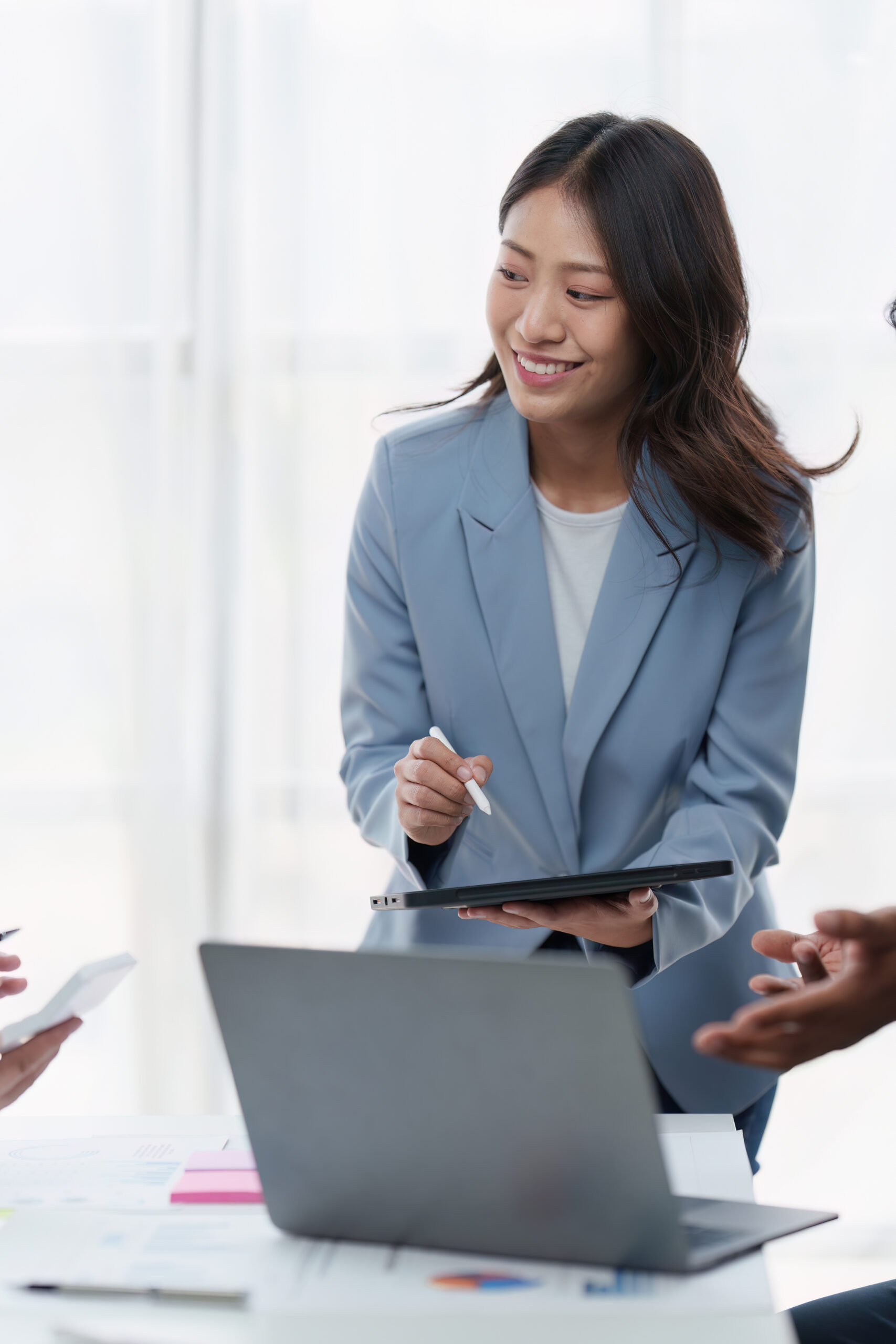 Group of Business People Meeting analysis financial plan, discussion, research with paperwork at office, accounting concept Smiling Asian businesswoman holding a tablet during a business meeting, actively engaged in planning and analysis for logistics BPO services.